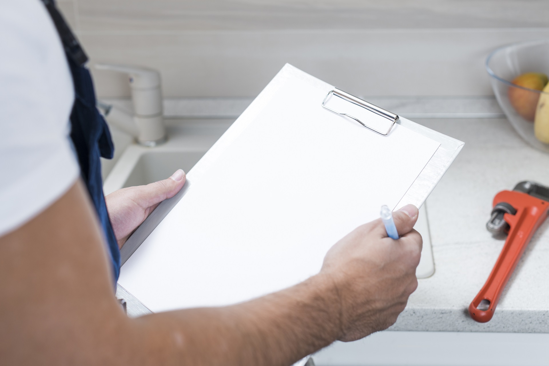 Plumber holding clipboard making list of plumbing issues