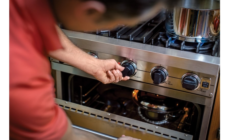 Man using his kitchen stove appliance that runs on propane.