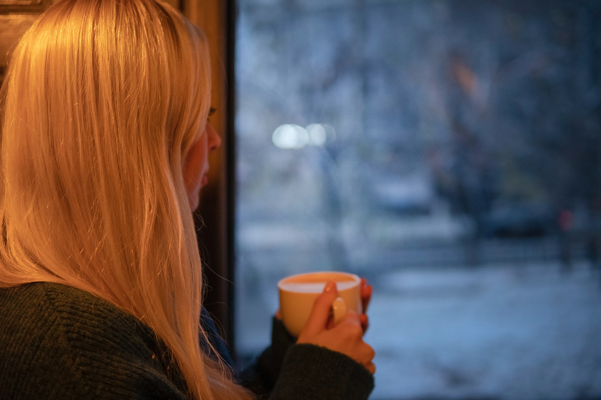 Woman looking outside of her window on a cold winter day