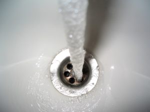 Drain in a bathroom that requires a cleaning to prevent clogging