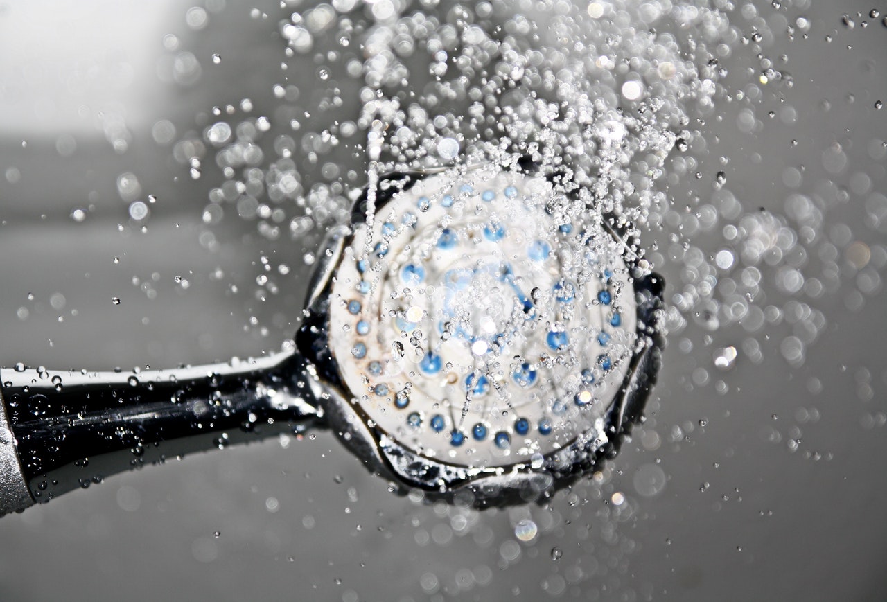 Close up of water wasting because of a long shower. Shower head close up