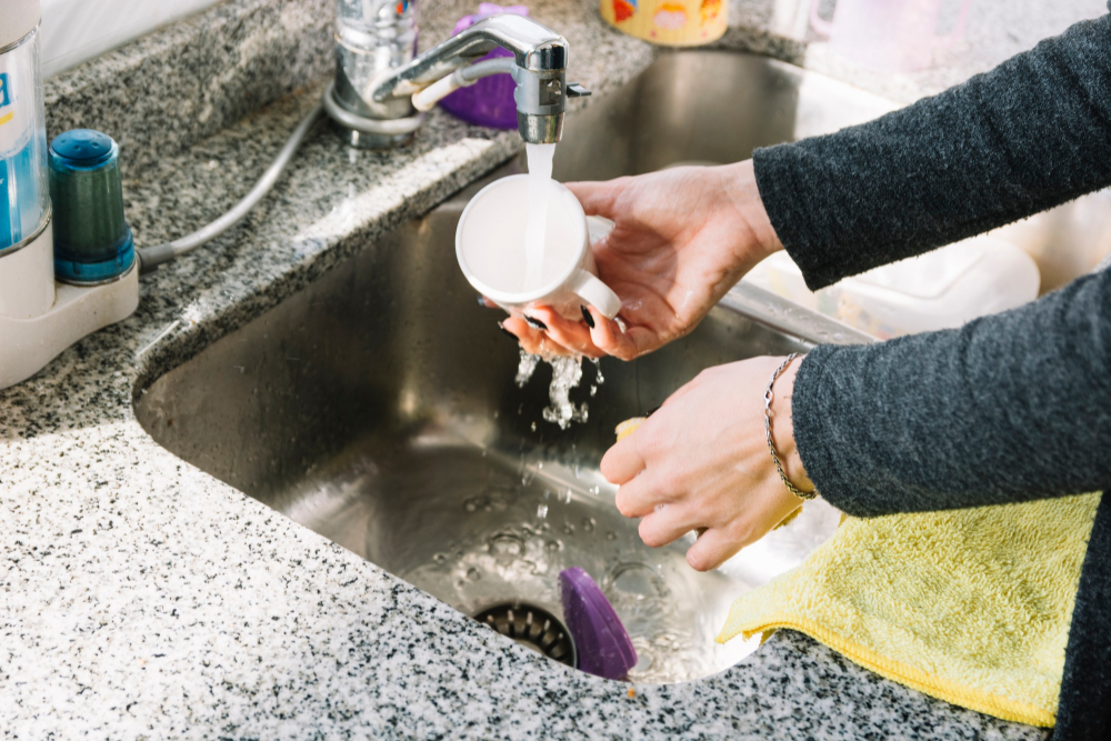 Washing dishes in a kitchen sink with  a drain screen or grate