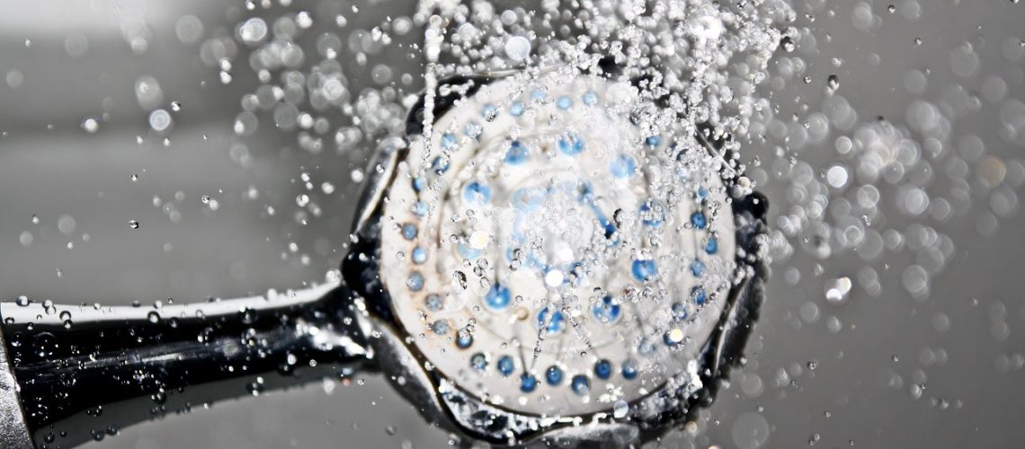 Close up of water wasting because of a long shower. Shower head close up