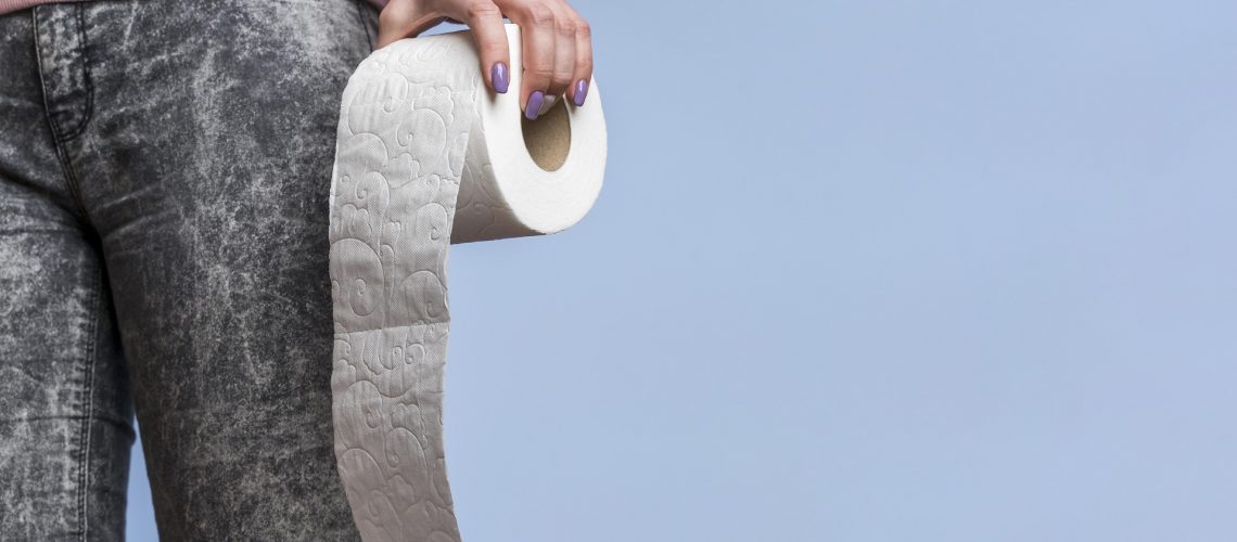 Woman holding a roll of toilet paper