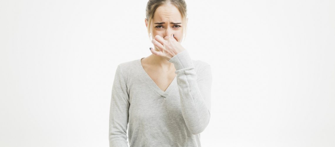 Woman plugging her nose because of bad sewer smell